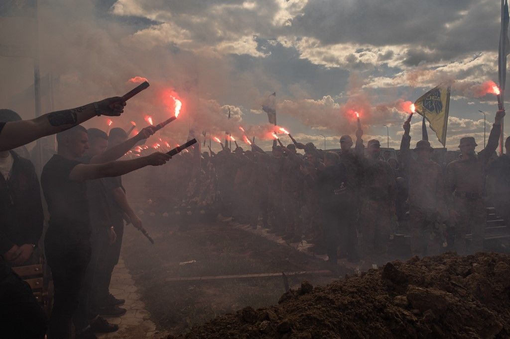 Az Azov Brigád harcosai és más katonák jelzőlámpákat tartanak az  Azovi-dandár egyik katonájának a temetésén. (Fotó: AGFP/Roman PILIPEY)