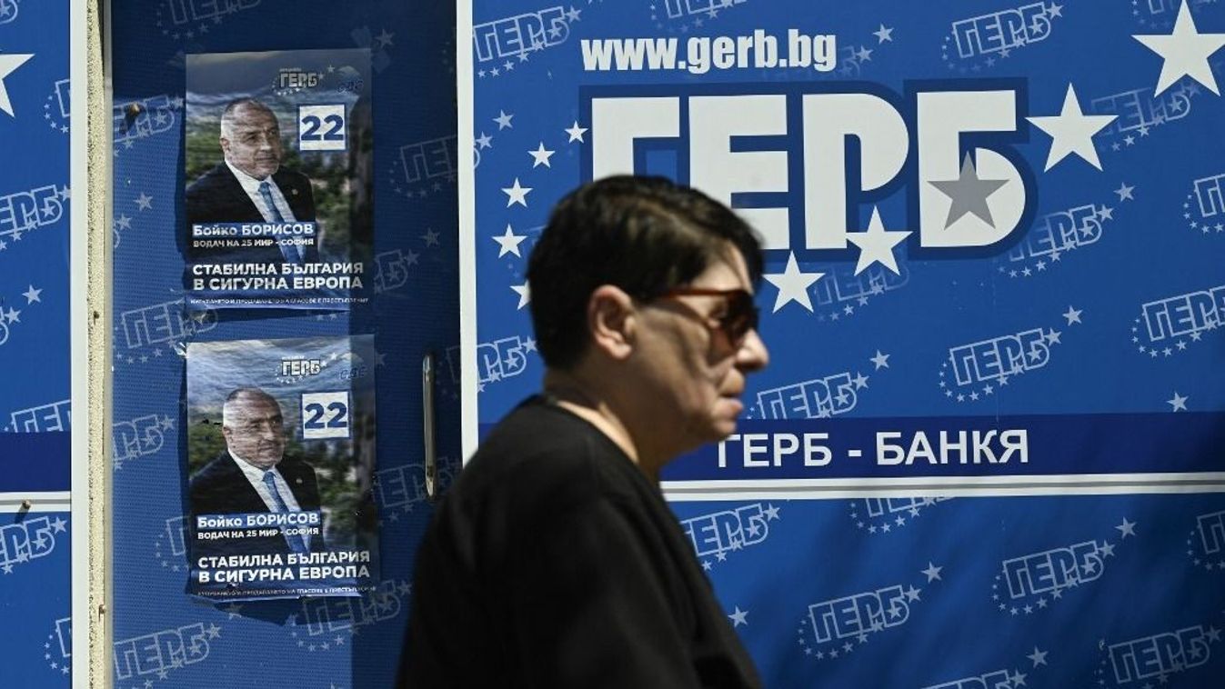Egy nő sétál a jobbközép GERB párt vezetőjének, Bojko Boriszov volt miniszterelnöknek a kampányplakátjai mellett Szófiában 2024. június 7-én, az európai parlamenti választások előtt