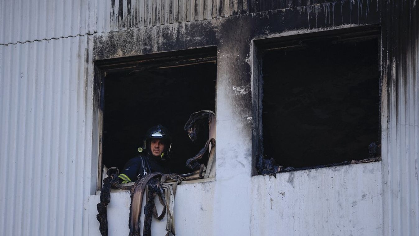 Egy francia tűzoltó néz ki az ablakon 2024. július 18-án a dél-franciaországi Nizza munkásnegyedében. (Fotó: Valerij HACHE / AFP)