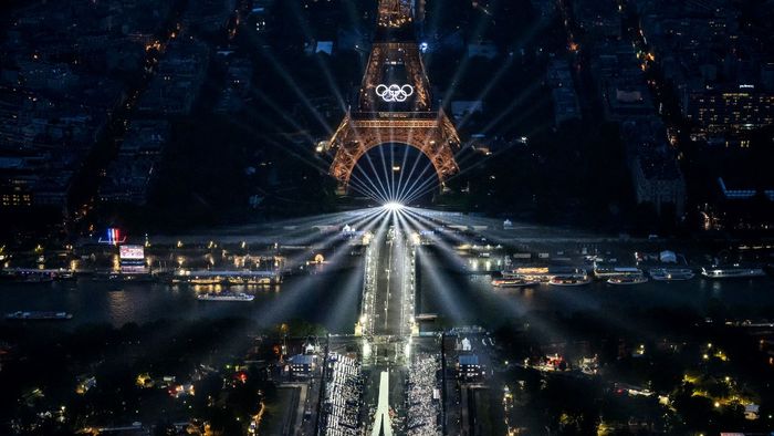 A photograph taken from an helicopter on July 26, 2024 shows an aerial view of the Eiffel Tower and the Olympics Rings lightened up during the opening ceremony of the Paris 2024 Olympic Games in Paris. (Photo by Lionel BONAVENTURE / POOL / AFP)