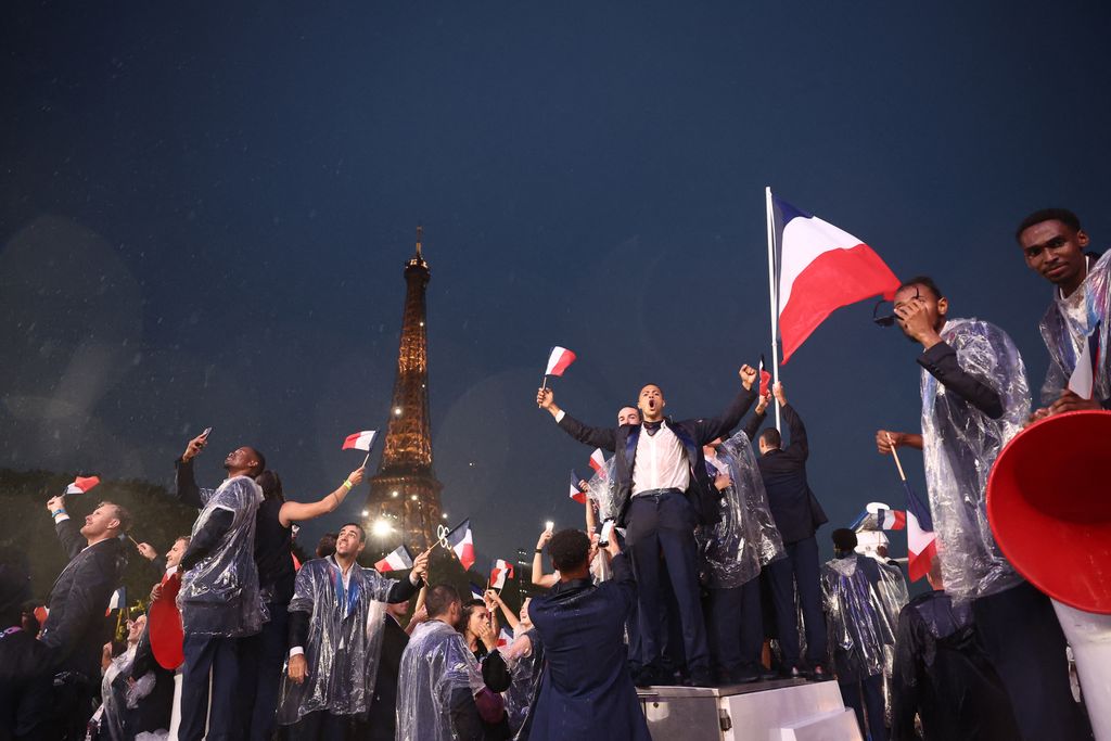 Athletes from France's delegation sail below the Eiffel Tower in a boat along the river Seine during the opening ceremony of the Paris 2024 Olympic Games in Paris on July 26, 2024. (Photo by Franck FIFE / POOL / AFP)