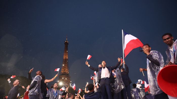 Athletes from France's delegation sail below the Eiffel Tower in a boat along the river Seine during the opening ceremony of the Paris 2024 Olympic Games in Paris on July 26, 2024. (Photo by Franck FIFE / POOL / AFP)