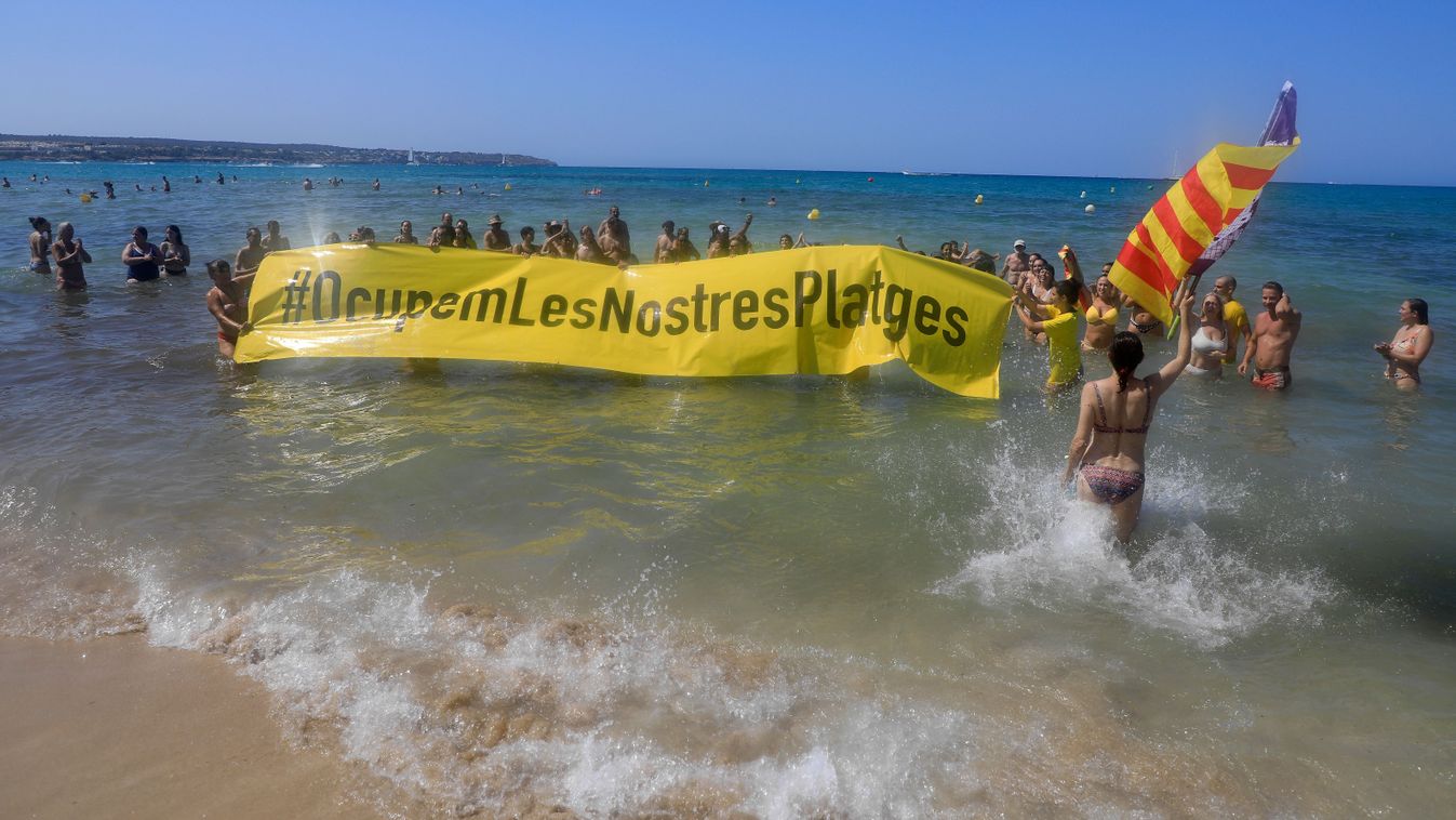 Protest against mass tourism on Mallorca
11 August 2024, Spain, El Arenal: People hold a banner "#They occupy our beaches" on a beach in Mallorca in protest against mass tourism on the Balearic island. The protest took place near Ballemann 6, one of the main attractions for German tourists in the Arenal beach area on Mallorca. Photo: Clara Margais/dpa (Photo by Clara Margais / DPA / dpa Picture-Alliance via AFP)