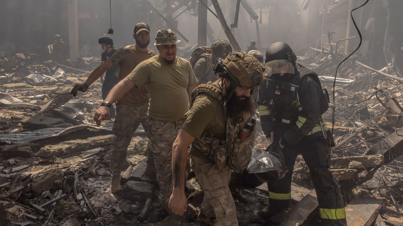 Ukrainian emergency and rescue personnel together with military members carry a body of a victim killed following a Russian strike on a supermarket, in Kostyantynivka, eastern Donetsk region, on August 9, 2024, amid the Russian invasion of Ukraine. A Russian strike on a supermarket in the eastern Ukrainian town of Kostyantynivka on August 9, killed at least 10 people and injured 35, Ukraine's interior minister said. The town is about 13 kilometres (eight miles) from the nearest Russian positions and faces almost daily strikes. (Photo by Roman PILIPEY / AFP)