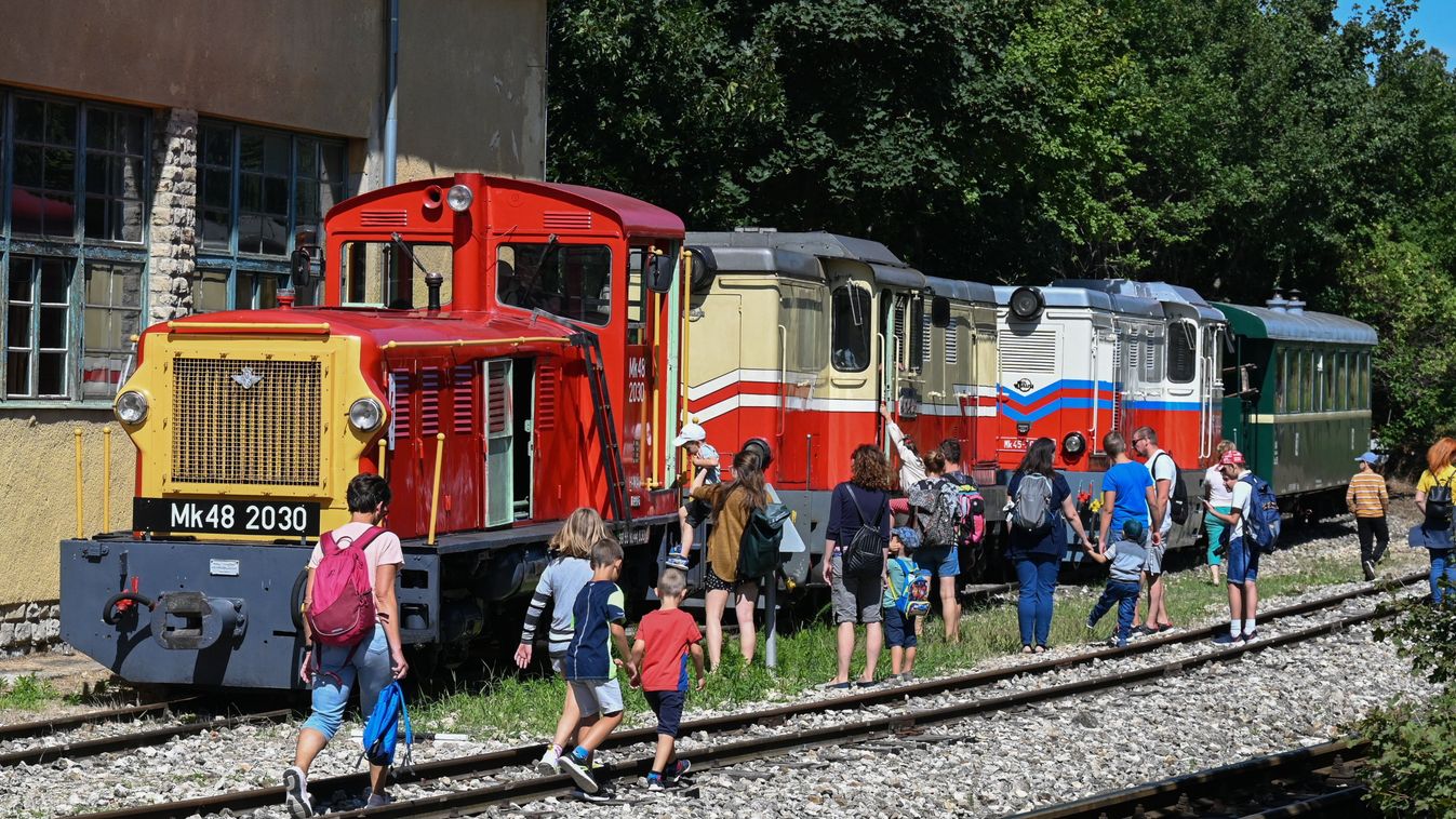 Budapest, 2023. július 31.
Résztvevõk a jármûkiállításon a gyermekvasút Széchenyihegy végállomásán, balról egy Mk48-as mozdony 2023. július 31-én. A Széchenyi-hegyi Gyermekvasúton 75 évvel ezelõtt, 1948. július 31-én indult el az elsõ vonat utasokkal, az évfordulóra emlékezve izgalmas programokkal várták a családokat, egykori úttörõ- és gyermekvasutasokat a Széchenyihegyen, az elsõ szakasz végállomásán.
MTI/Máthé Zoltán