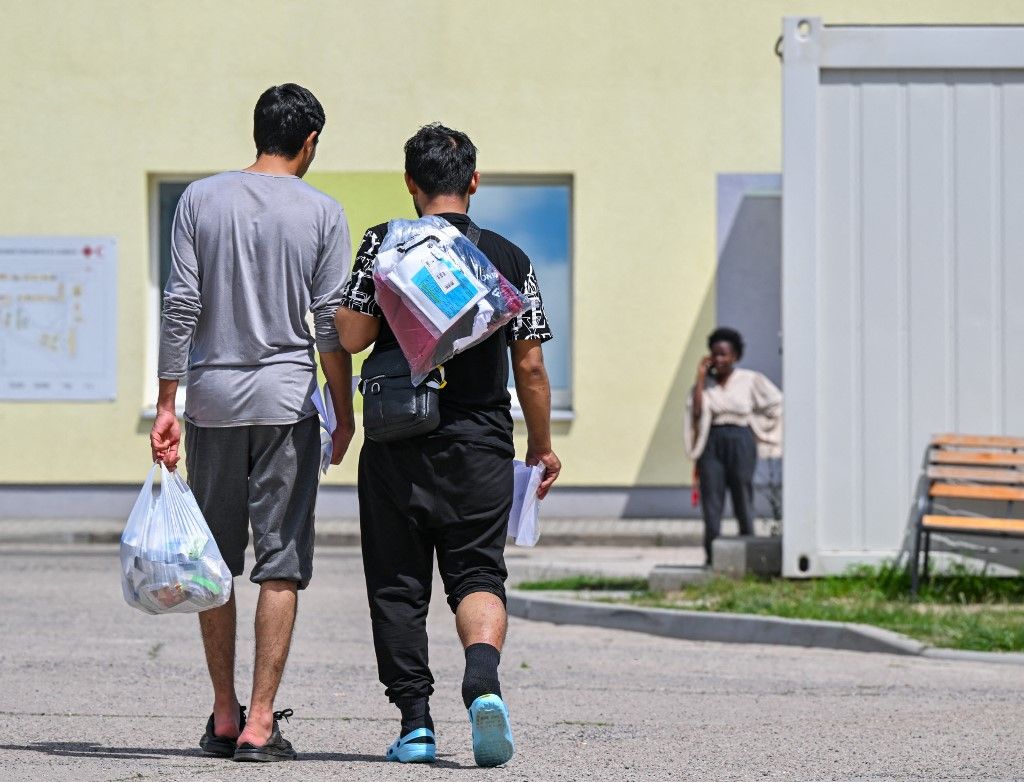 Két migráns sétál át a menedékkérők központi befogadó központja (ZABH) területén Brandenburg államban.