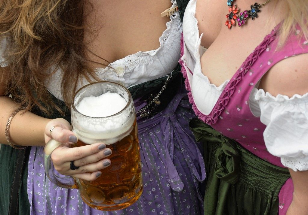 Hagyományos bajor dirndlibe öltözött lányok isszák a sört az Oktoberfest sörfesztiválon