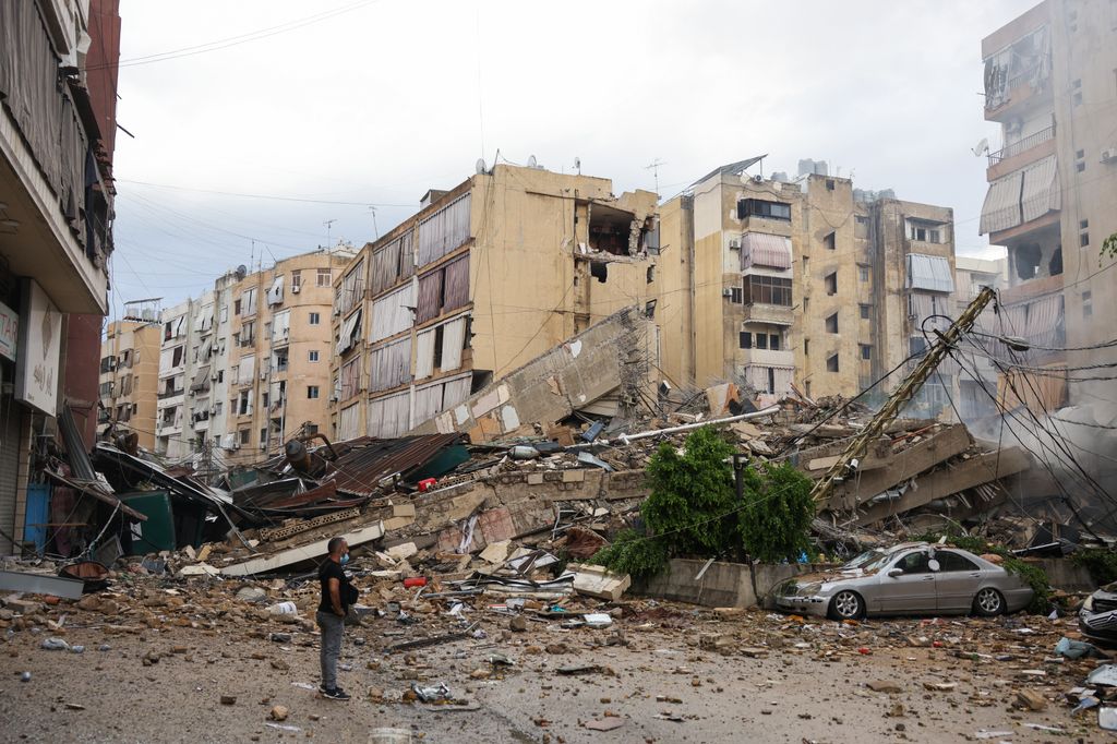 A man looks at the destruction at the site of an overnight Israeli airstrike on the Bir el-Abed neighbourhood in Beirut's southern suburbs on October 1, 2024.. (Photo by ANWAR AMRO / AFP)