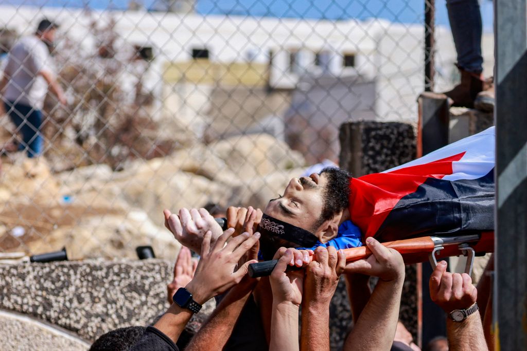 EDITORS NOTE: Graphic content / Mourners carry the body of Palestinian Deya Dwakat who was killed in an Israeli military raid the previous day in the occupied West Bank, during a funeral in Balatah on October 2, 2024. (Photo by Jaafar ASHTIYEH / AFP)