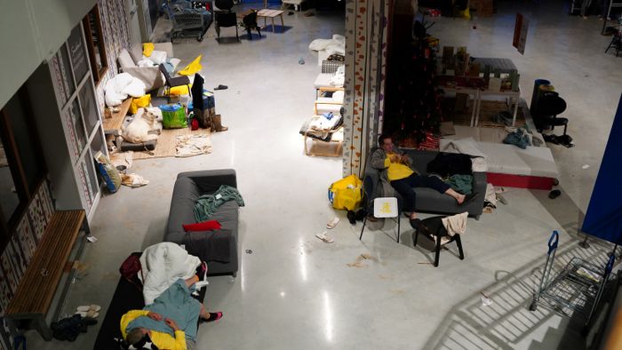 Residents rest in an emergency shelter set in an Ikea store following deadly floods in Alfafar neighbourhood, south of Valencia, eastern Spain, on October 30, 2024. Floods triggered by torrential rains in Spain's eastern Valencia region has left at least 70 people dead, rescue services said on October 30. (Photo by Manaure Quintero / AFP)