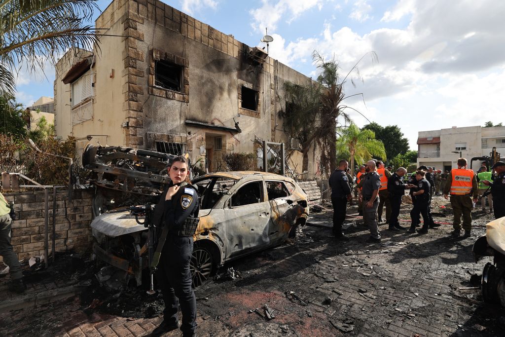 First responders and Israeli security forces gather amid debris and charred vehicles in Kiryat Bialik in the Haifa district of Israel, following a reported strike by Lebanon's Hezbollah on September 22, 2024. Hezbollah said on September 22 that it targeted military production facilities and an air base near north Israel's Haifa after the Israeli military pounded south Lebanon and said it targeted thousands of rocket launcher barrels. (Photo by Jack GUEZ / AFP)