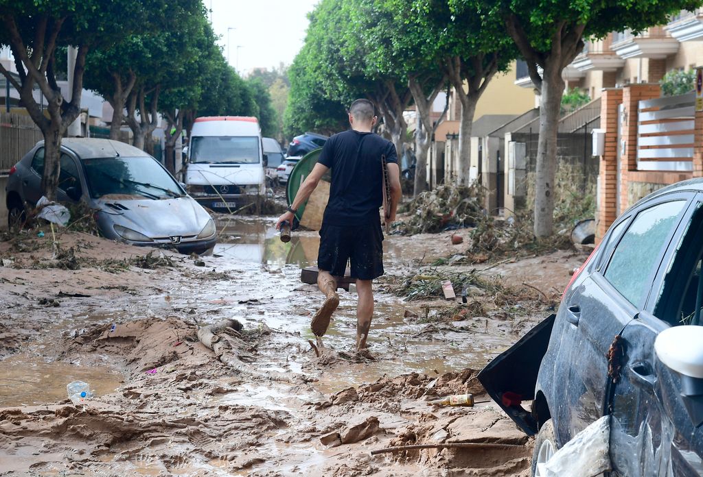 A man walks in a street covered in mud in a flooded area in Picanya, near Valencia, eastern Spain, on October 30, 2024. Floods triggered by torrential rains in Spain's eastern Valencia region has left 51 people dead, rescue services said on October 30. (Photo by Jose Jordan / AFP)