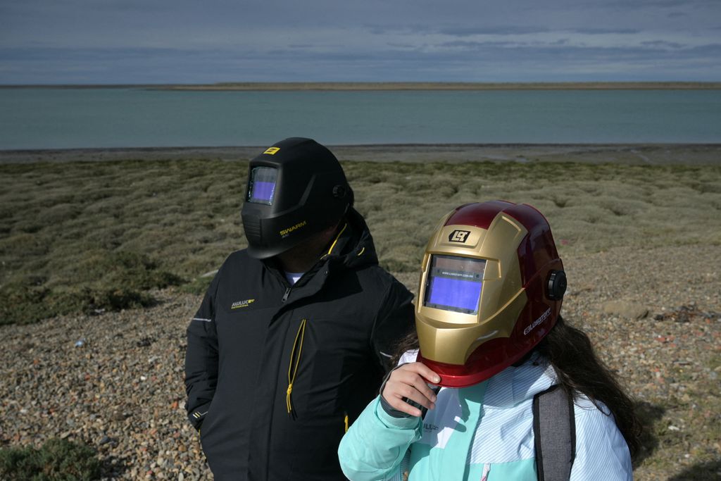 People wear a protective mask to watch the solar annular eclipse in Puerto San Julian, Santa Cruz province, Argentina, on October 2, 2024 (Photo by Juan MABROMATA / AFP)