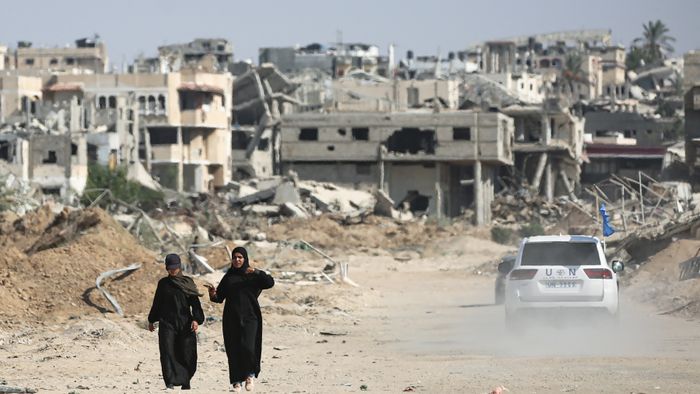 Palestinians walk past destruction and a UN vehicle in Khan Yunis in the southern Gaza Strip on September 10, 2024, amid the ongoing war between Israel and Palestinian militant group Hamas. (Photo by Eyad BABA / AFP)