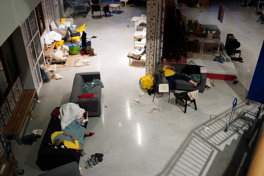 Residents rest in an emergency shelter set in an Ikea store following deadly floods in Alfafar neighbourhood, south of Valencia, eastern Spain, on October 30, 2024. Floods triggered by torrential rains in Spain's eastern Valencia region has left at least 70 people dead, rescue services said on October 30. (Photo by Manaure Quintero / AFP)