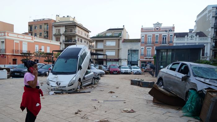 A resident talks on phone next to piled up cars following deadly floods in Alfafar neighbourhood, south of Valencia, eastern Spain, on October 30, 2024. Floods triggered by torrential rains in Spain's eastern Valencia region has left at least 70 people dead, rescue services said on October 30. (Photo by Manaure Quintero / AFP)