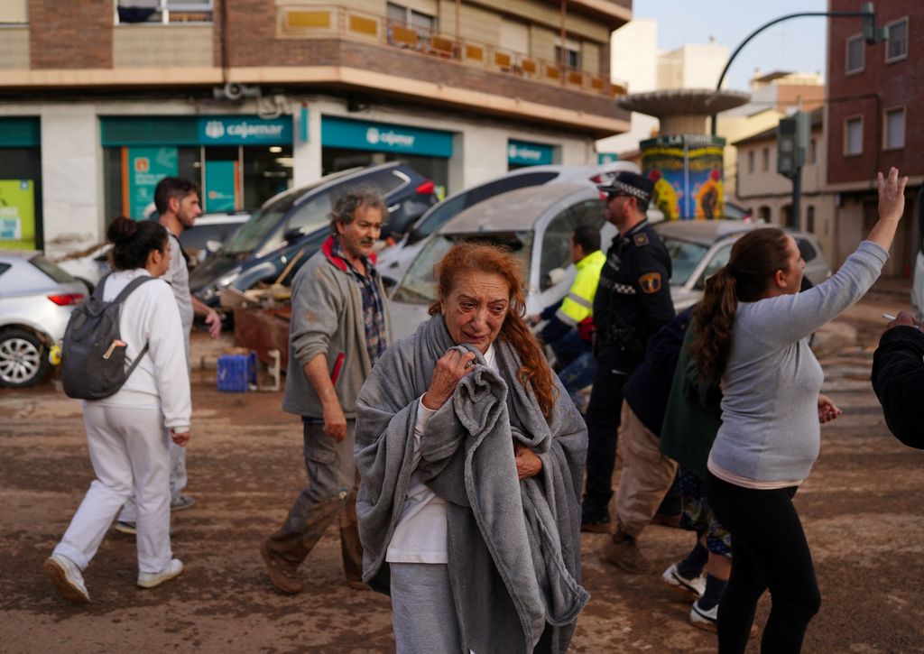 A woman reacts in a street covered in mud following deadly floods  in Valencia's De La Torre neighbourhood, eastern Spain, on October 30, 2024. Floods triggered by torrential rains in Spain's eastern Valencia region has left at least 70 people dead, rescue services said on October 30. (Photo by Manaure QUINTERO / AFP)