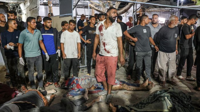 EDITORS NOTE: Graphic content / Bodies of victims of an Israeli strike that targeted a mosque-turned-shelter in Deir al-Balah in the central Gaza Strip, are laid in the courtyard of the al-Aqsa Martyrs hospital for identification during the night of October 6, 2024, amid the ongoing war between Israel and the Palestinian Hamas movement. Gaza's civil defence agency said on October 6 that an Israeli strike on the mosque-turned-shelter in central Deir al-Balah killed 21 people, while Israel's military said it had targeted Hamas militants. (Photo by BASHAR TALEB / AFP)