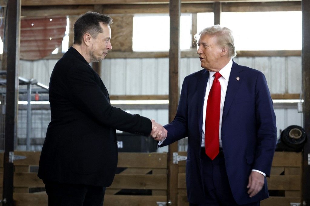 Elon Musk (L) kezet fog a republikánus elnökjelölttel, Donald Trump korábbi elnökkel a Butler Farm Show területén tartott kampánygyűlésen