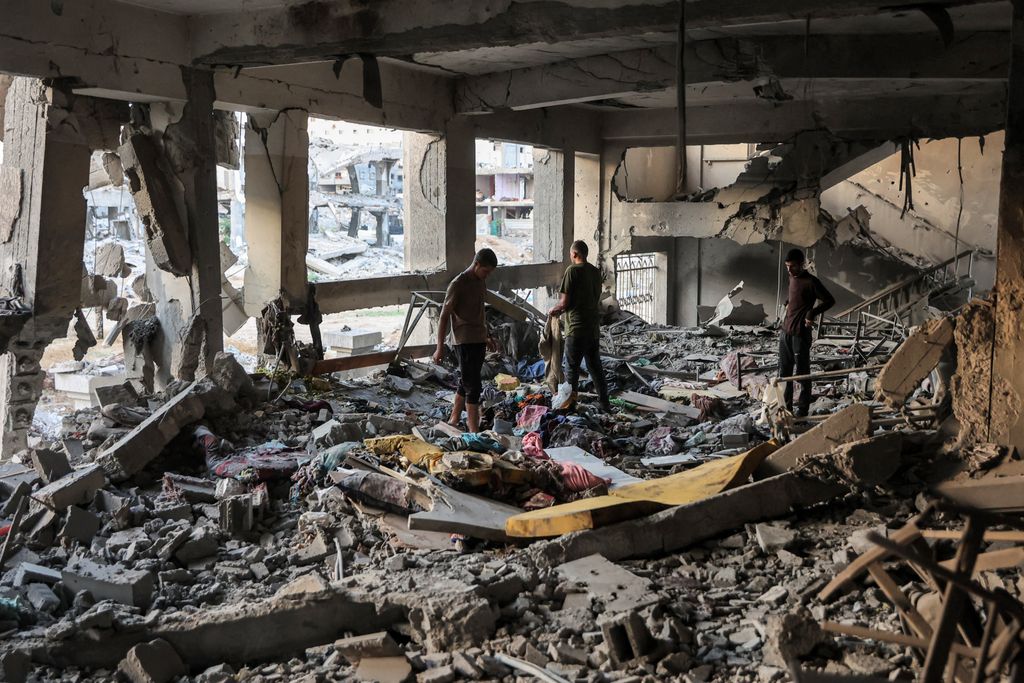 People inspect a destroyed classroom in the aftermath of Israeli bombardment on the Palestinian Muscat Governmental School, funded by Omani aid, in Gaza City on October 2, 2024 amid the ongoing war in the Palestinian territory between Israel and Hamas. (Photo by Omar AL-QATTAA / AFP)