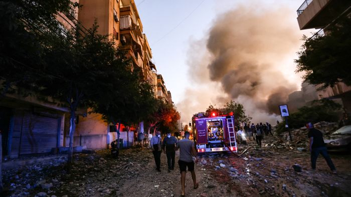 People and a fire truck rush to the scene of an Israeli air strike in the Haret Hreik neighbourhood of Beirut's southern suburbs on September 27, 2024. A source close to Hezbollah said the massive Israeli strikes on Beirut's southern suburbs flattened six buildings. (Photo by Ibrahim AMRO / AFP)