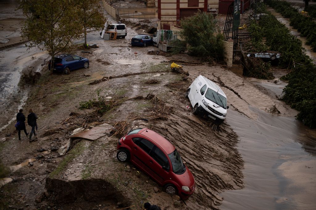 Cars taken in a mudslide are pictured in a flooded street in Alora, near Malaga, on October 30, 2024, after heavy rains hit southern Spain. Heavy rains hit southern Spain on October 30, 2024. Floods in eastern Valencia region has left at least 70 people dead. (Photo by JORGE GUERRERO / AFP)