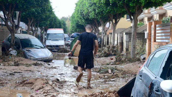 A man walks in a street covered in mud in a flooded area in Picanya, near Valencia, eastern Spain, on October 30, 2024. Floods triggered by torrential rains in Spain's eastern Valencia region has left 51 people dead, rescue services said on October 30. (Photo by Jose Jordan / AFP)