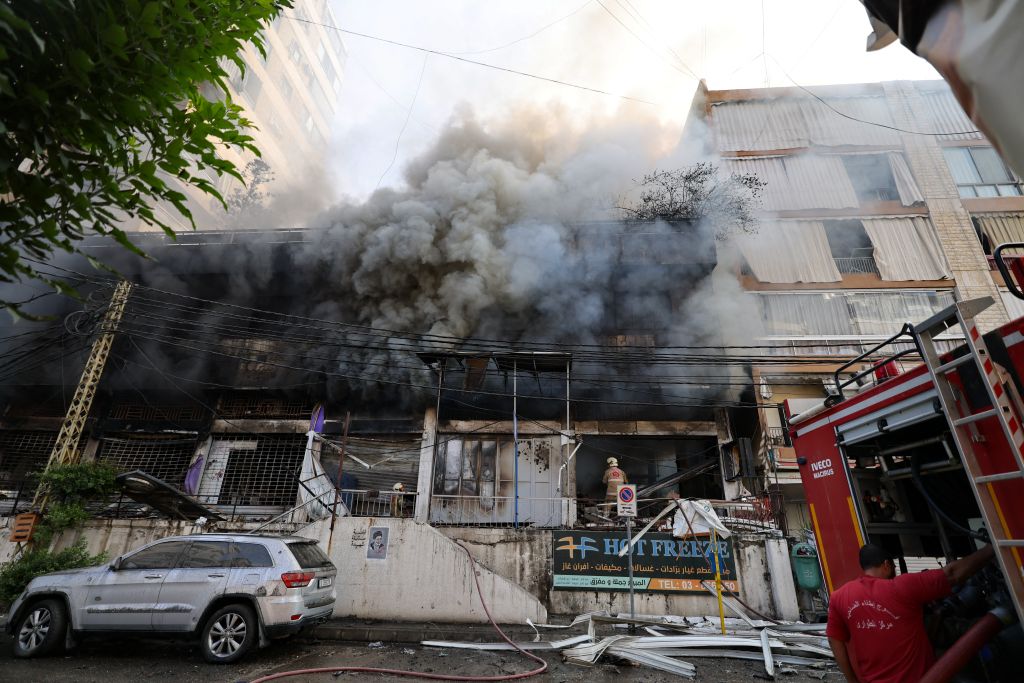 First responders fight the blaze inside a building set on fire by an Israeli strike that targeted Beirut’s southern suburbs on October 6, 2024. A huge fireball lit up the night sky and plumes of smoke rose over south Beirut early on October 6 as Israel unleashed intense air strikes targeting Hezbollah, nearly a year since the Gaza war erupted. (Photo by ANWAR AMRO / AFP)