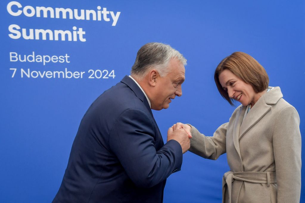 European PolHungary's Prime Minister Viktor Orban (L) greets President of Moldova Maia Sandu upon arrival for the European Political Community Summit in Budapest, on November 7, 2024. (Photo by Ferenc ISZA / AFP)itical Community summit