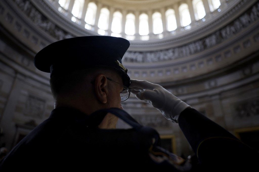 Egy amerikai capitoliumi rendőrtiszt  tiszteleg a kongresszusi aranyérem átadásán annak a 13 amerikai katonának, akik az afganisztáni Hamid Karzai nemzetközi repülőtéren öngyilkos merényletben haltak meg