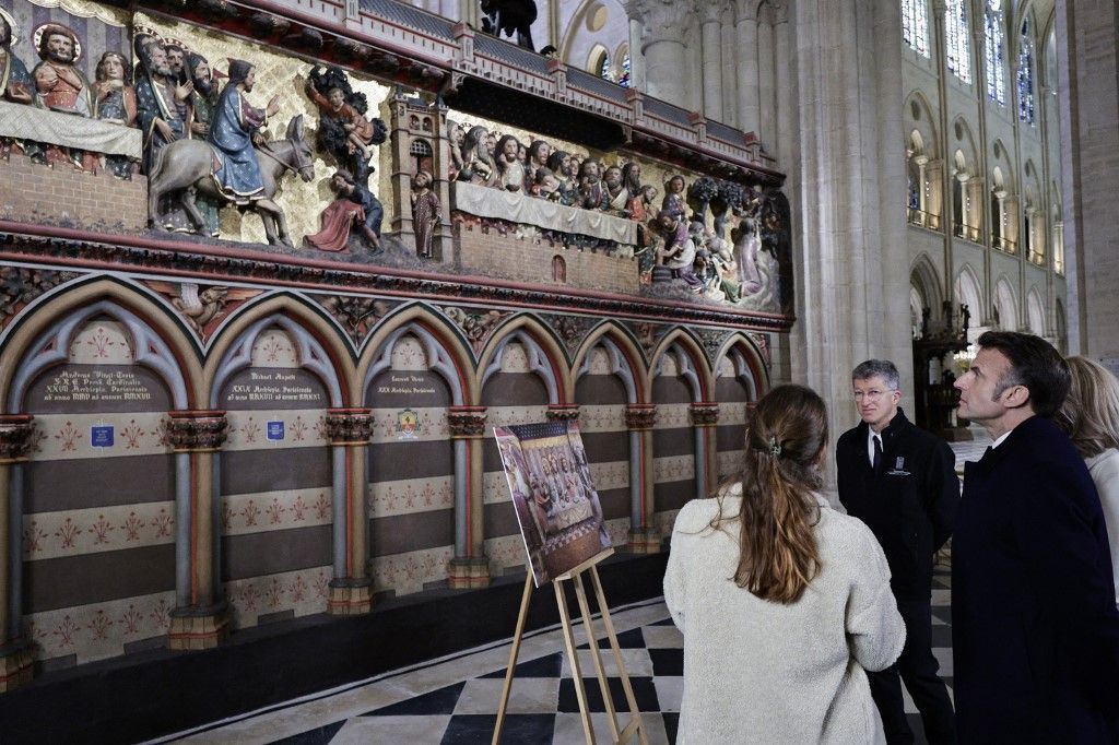 French President Emmanuel Macron (C-L) applauds with attendees, including workers of reconstruction of Notre-Dame de Paris cathedral, during his visit to the cathedral in Paris, on November 29, 2024. The Notre-Dame Cathedral is set to re-open early December 2024, with a planned weekend of ceremonies on December 7 and 8, 2024, five years after the 2019 fire which ravaged the world heritage landmark and toppled its spire. (Photo by Sarah Meyssonnier / POOL / AFP)