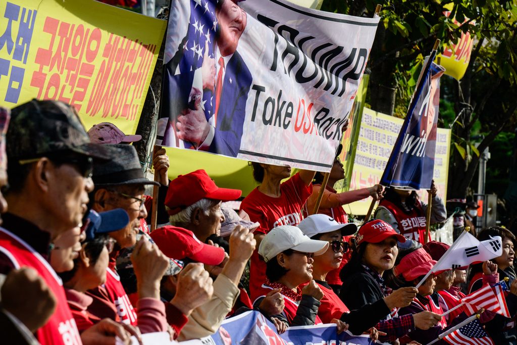 Supporters of former US President and Republican presidential candidate Donald Trump hold banners and chant slogans during a rally a block away from the US Embassy in Seoul on November 5, 2024. (Photo by Anthony WALLACE / AFP)