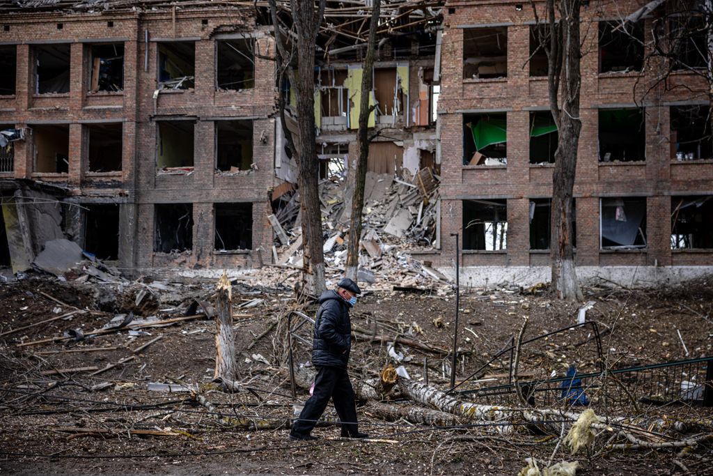 A man walks in front of a destroyed building after a Russian missile attack in the town of  Vasylkiv, near Kyiv, on February 27, 2022. Ukraine's foreign minister said on February 27, that Kyiv would not buckle at talks with Russia over its invasion, accusing President Vladimir Putin of seeking to increase "pressure" by ordering his nuclear forces on high alert. (Photo by Dimitar DILKOFF / AFP)