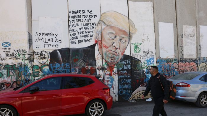 A Palestinian man walks past a mural depicting US former president and current Republican presidential candidate Donald Trump on Israel's controversial separation wall in Bethlehem in the occupied West Bank on November 5, 2024. (Photo by Hazem BADER / AFP)