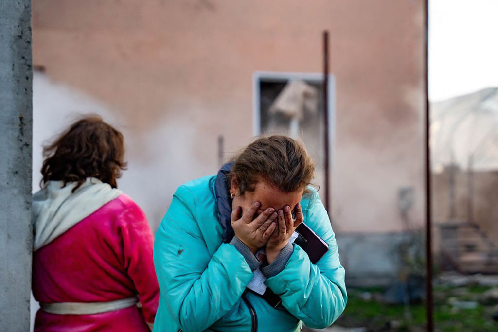 In this handout photograph taken and released by the Ukrainian Emergency Service on November 17, 2024, a woman reacts in the courtyard of a damaged building following a missile attack at an undisclosed location in Odesa region. Russia pounded Ukraine with "one of the largest" aerial attacks it has suffered in an assault that targeted the country's energy infrastructure, Kyiv's Foreign Minister Andriy Sybiga said on November 17, 2024. (Photo by Handout / UKRAINIAN EMERGENCY SERVICE / AFP) / RESTRICTED TO EDITORIAL USE - MANDATORY CREDIT "AFP PHOTO / UKRAINIAN EMERGENCY SERVICE" - NO MARKETING NO ADVERTISING CAMPAIGNS - DISTRIBUTED AS A SERVICE TO CLIENTS