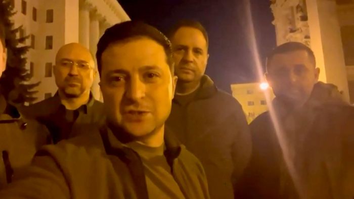 This screen grab taken from a video made available on the Facebook account of the President of Ukraine Volodymyr Zelensky, shows himself speaking face camera on February 25, 2022. Ukraine's President Volodymyr Zelensky says 'we are all here' in Kyiv in a video posted on his Facebook account, standing near the presidency building along with his advisers. (Photo by FACEBOOK / @Volodymyr Zelensky / AFP) / RESTRICTED TO EDITORIAL USE - MANDATORY CREDIT "AFP PHOTO / Facebook account of Volodymyr Zelensky" - NO MARKETING - NO ADVERTISING CAMPAIGNS - DISTRIBUTED AS A SERVICE TO CLIENTS