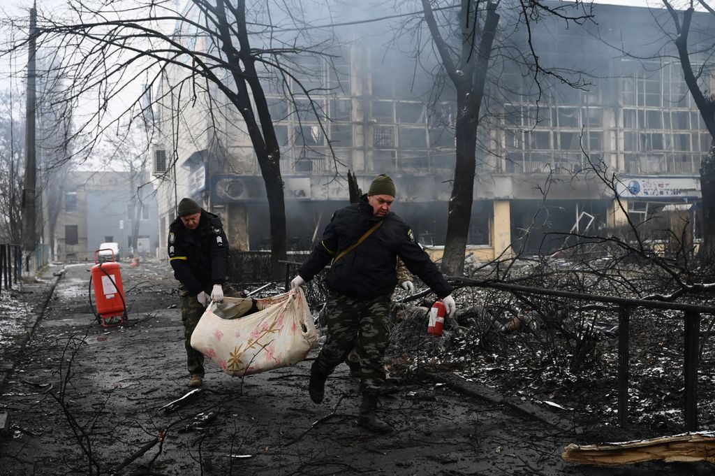 EDITORS NOTE: Graphic content / Police officers remove the body of a passerby killed in yesterday's airstrike that hit Kyiv's main television tower in Kyiv on March 2, 2022. An apparent Russian airstrike hit Kyiv's main television tower in the heart of the Ukrainian capital on March 1, 2022. (Photo by ARIS MESSINIS / AFP)