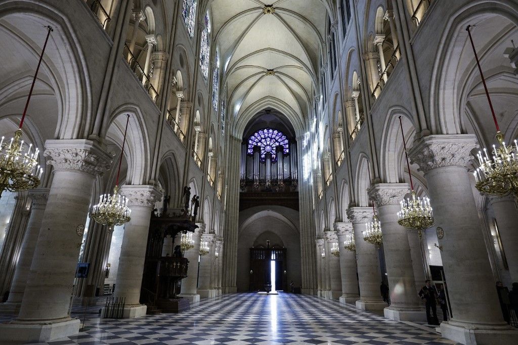 French President Emmanuel Macron (C-L) applauds with attendees, including workers of reconstruction of Notre-Dame de Paris cathedral, during his visit to the cathedral in Paris, on November 29, 2024. The Notre-Dame Cathedral is set to re-open early December 2024, with a planned weekend of ceremonies on December 7 and 8, 2024, five years after the 2019 fire which ravaged the world heritage landmark and toppled its spire. (Photo by Sarah Meyssonnier / POOL / AFP)