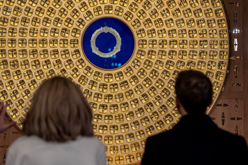 French President Emmanuel Macron (R) and his wife Brigitte Macron look at the Crown of Thorns and the reliquary of the Crown of Thorns designed by French artist Sylvain Dubuisson during their visit at the Notre-Dame de Paris Cathedral in Paris, on November 29, 2024. The Notre-Dame Cathedral is set to re-open early December 2024, with a planned weekend of ceremonies on December 7 and 8, 2024, five years after the 2019 fire which ravaged the world heritage landmark and toppled its spire. (Photo by Christophe PETIT TESSON / POOL / AFP) / RESTRICTED TO EDITORIAL USE - MANDATORY MENTION OF THE ARTIST UPON PUBLICATION - TO ILLUSTRATE THE EVENT AS SPECIFIED IN THE CAPTION