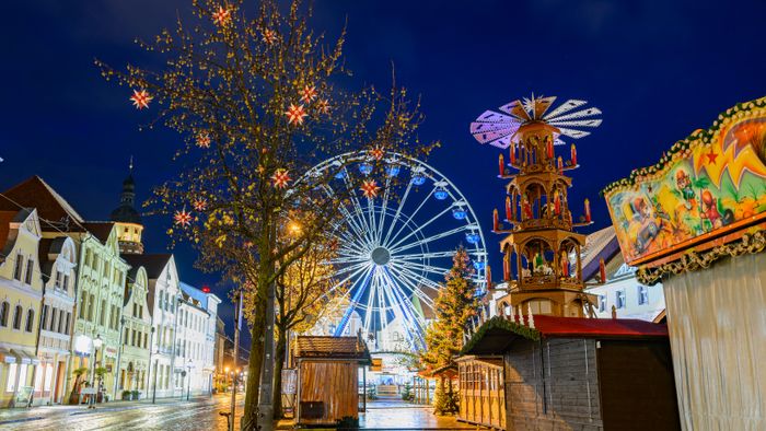 Cottbus Christmas market before opening20 November 2024, Brandenburg, Cottbus: A Ferris wheel and a pyramid stand together with closed stalls at the Cottbus Christmas Market of 1000 Stars in the evening. The Christmas market on the Altmarkt in Cottbus city center will open on 25.11.2024. Photo: Patrick Pleul/dpa/ZB (Photo by PATRICK PLEUL / DPA / dpa Picture-Alliance via AFP)