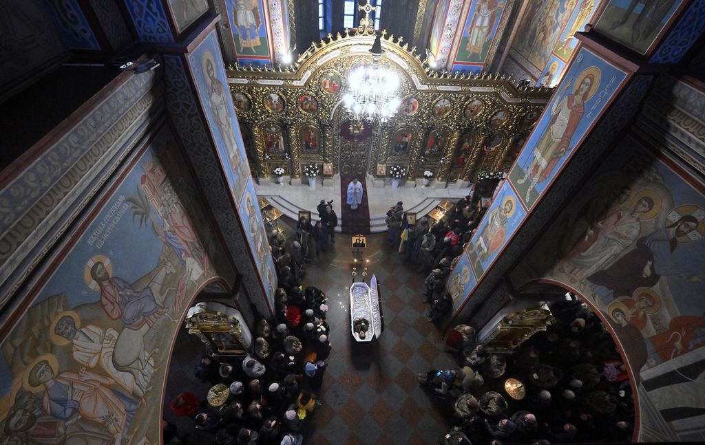 Relatives, colleagues and friends stand by the coffin of the combat medic Maria-Khrystyna Dvoinik, 32, during her funeral service at Saint Michael's Golden-domes Orthodox cathedral in Kyiv on November 15, 2024, amid Russian invasion in Ukraine. (Photo by Sergei SUPINSKY / AFP)