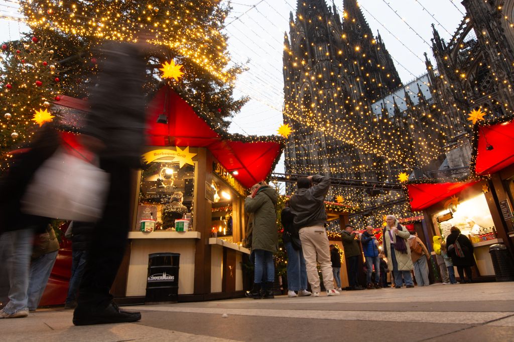 Christmas Market OpVisitors check the stalls selling Christmas decorations at Cologne Christmas in front of Dam Cathedral in Cologne, Germany, on November 18, 2024. (Photo by Ying Tang/NurPhoto) (Photo by Ying Tang / NurPhoto / NurPhoto via AFP)ens In Cologne