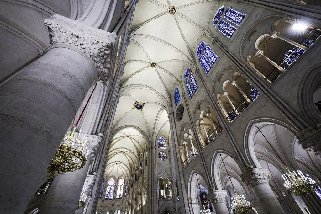 French President Emmanuel Macron (C-L) applauds with attendees, including workers of reconstruction of Notre-Dame de Paris cathedral, during his visit to the cathedral in Paris, on November 29, 2024. The Notre-Dame Cathedral is set to re-open early December 2024, with a planned weekend of ceremonies on December 7 and 8, 2024, five years after the 2019 fire which ravaged the world heritage landmark and toppled its spire. (Photo by Sarah Meyssonnier / POOL / AFP)