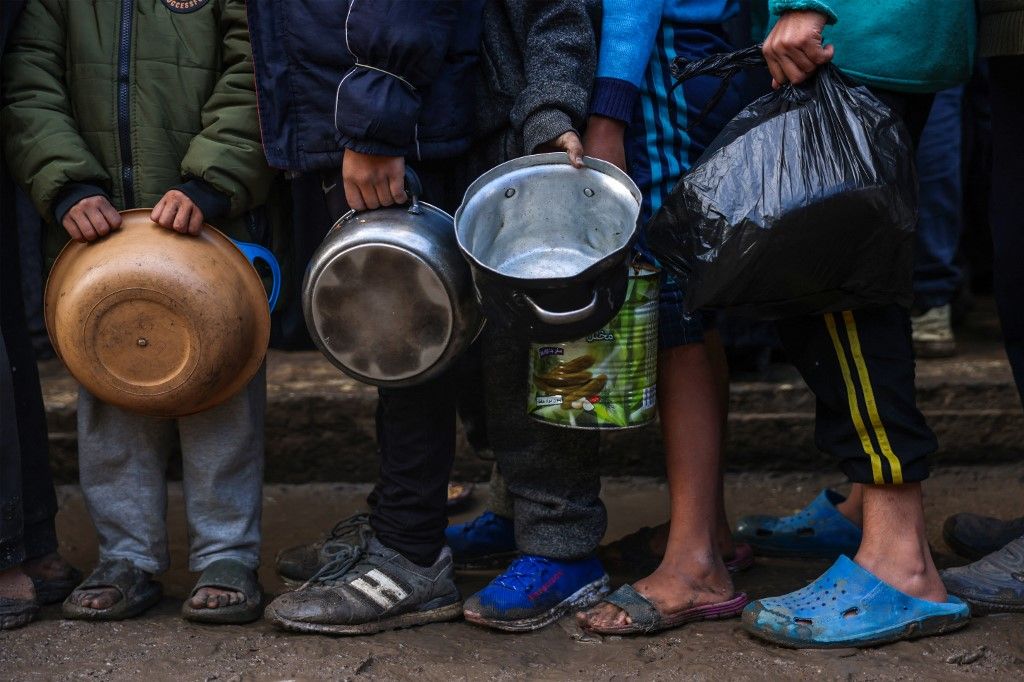 Displaced Palestinian children wait in line to receive food at a distribution centre in Deir el-Balah in the central Gaza Strip on November 26, 2024, amid the ongoing war between Israel and Hamas. (Photo by BASHAR TALEB / AFP)