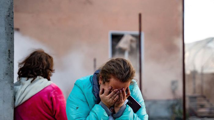 In this handout photograph taken and released by the Ukrainian Emergency Service on November 17, 2024, a woman reacts in the courtyard of a damaged building following a missile attack at an undisclosed location in Odesa region. Russia pounded Ukraine with "one of the largest" aerial attacks it has suffered in an assault that targeted the country's energy infrastructure, Kyiv's Foreign Minister Andriy Sybiga said on November 17, 2024. (Photo by Handout / UKRAINIAN EMERGENCY SERVICE / AFP) / RESTRICTED TO EDITORIAL USE - MANDATORY CREDIT "AFP PHOTO / UKRAINIAN EMERGENCY SERVICE" - NO MARKETING NO ADVERTISING CAMPAIGNS - DISTRIBUTED AS A SERVICE TO CLIENTS