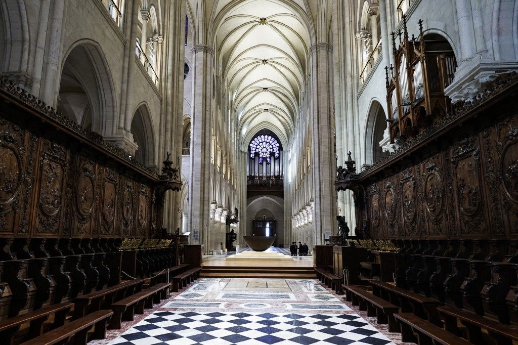 French President Emmanuel Macron (C-L) applauds with attendees, including workers of reconstruction of Notre-Dame de Paris cathedral, during his visit to the cathedral in Paris, on November 29, 2024. The Notre-Dame Cathedral is set to re-open early December 2024, with a planned weekend of ceremonies on December 7 and 8, 2024, five years after the 2019 fire which ravaged the world heritage landmark and toppled its spire. (Photo by Sarah Meyssonnier / POOL / AFP)