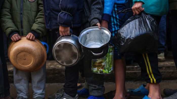 Displaced Palestinian children wait in line to receive food at a distribution centre in Deir el-Balah in the central Gaza Strip on November 26, 2024, amid the ongoing war between Israel and Hamas. (Photo by BASHAR TALEB / AFP)