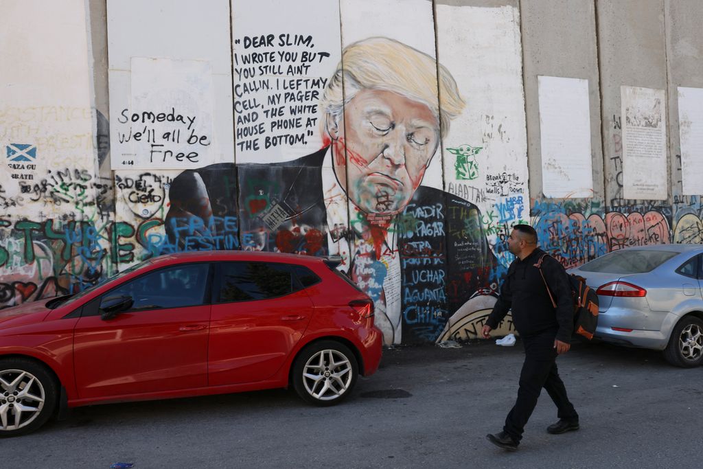 A Palestinian man walks past a mural depicting US former president and current Republican presidential candidate Donald Trump on Israel's controversial separation wall in Bethlehem in the occupied West Bank on November 5, 2024. (Photo by Hazem BADER / AFP)