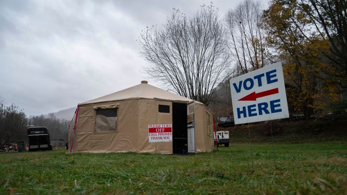 A 'vote here' sign is seen outside of a temporary voting site located in a tent that is also sheltering volunteer police due to damages caused by Hurricane Helene, on Election Day, November 5, 2024, in Burnsville, North Carolina. (Photo by Allison Joyce / AFP)