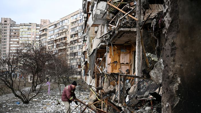 A man clears debris at a damaged residential building at Koshytsa Street, a suburb of the Ukrainian capital Kyiv, where a military shell allegedly hit, on February 25, 2022. Russian forces reached the outskirts of Kyiv on Friday as Ukrainian President Volodymyr Zelensky said the invading troops were targeting civilians and explosions could be heard in the besieged capital. Pre-dawn blasts in Kyiv set off a second day of violence after Russian President Vladimir Putin defied Western warnings to unleash a full-scale ground invasion and air assault on Thursday that quickly claimed dozens of lives and displaced at least 100,000 people. (Photo by Daniel LEAL / AFP)